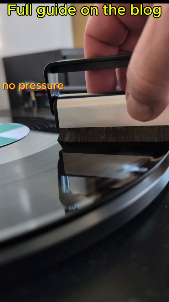Draw the brush towards you, across the radius of the record to the outer edge.