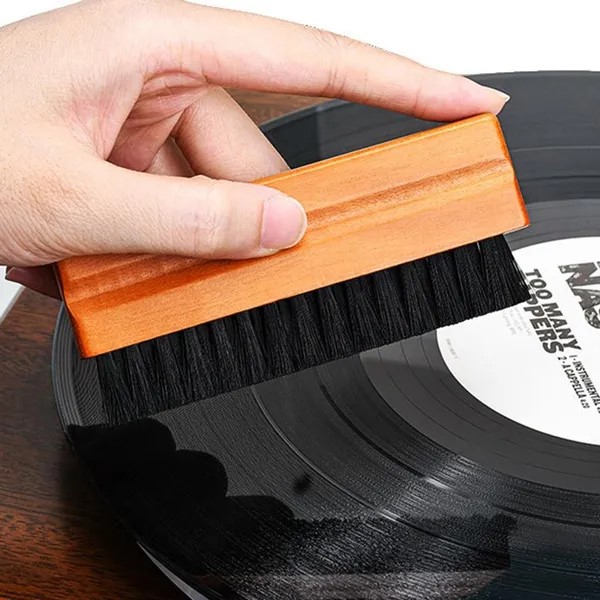 Unsuitable brush for vinyl records with long stiff bristles being used on a record surface.