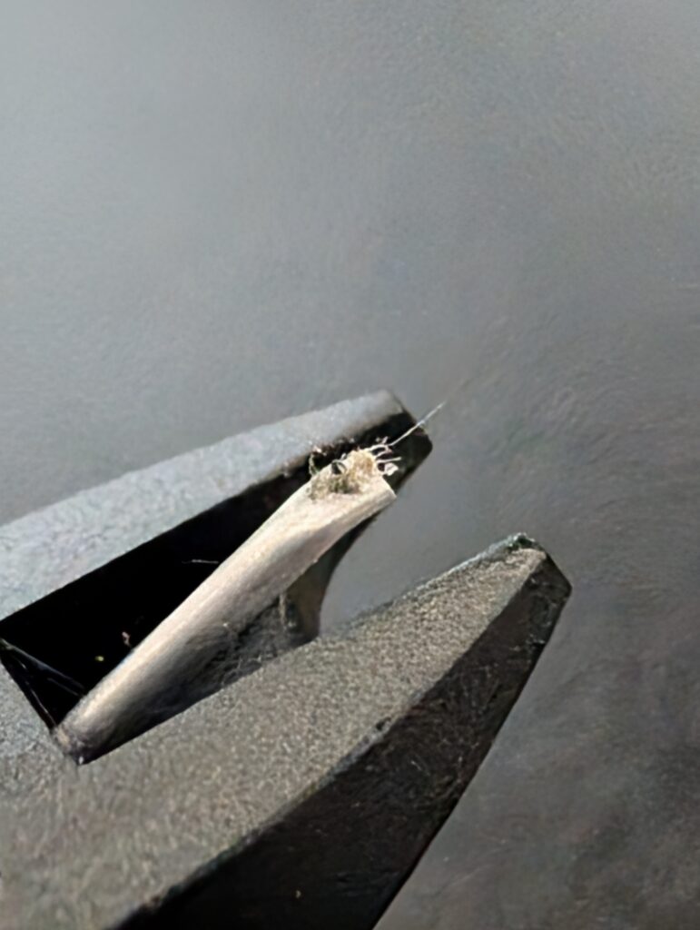 Ortofon M10 stylus with dust and paper fibres after playing a record stored in a paper inner sleeve without brushing.