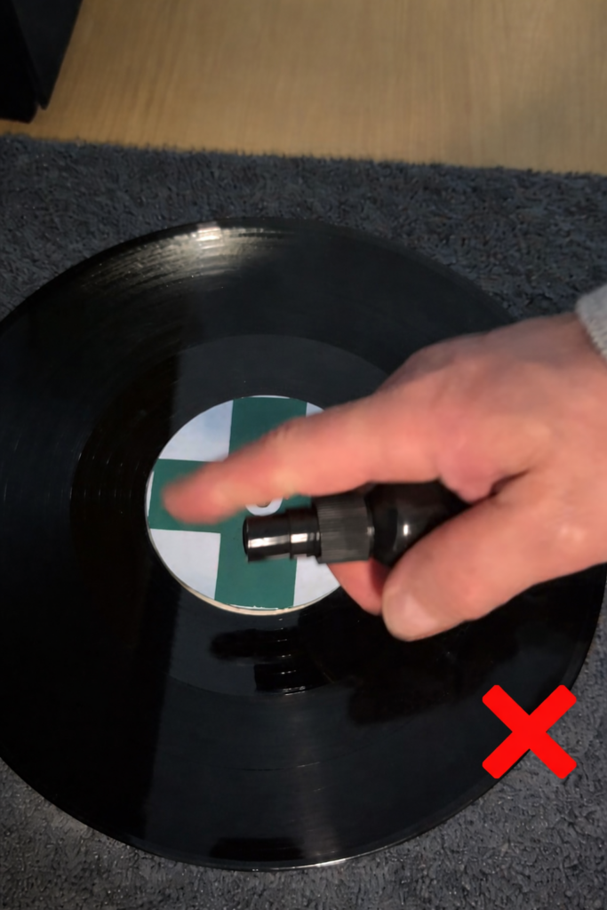 Do not spray the record. Spray the cloth.